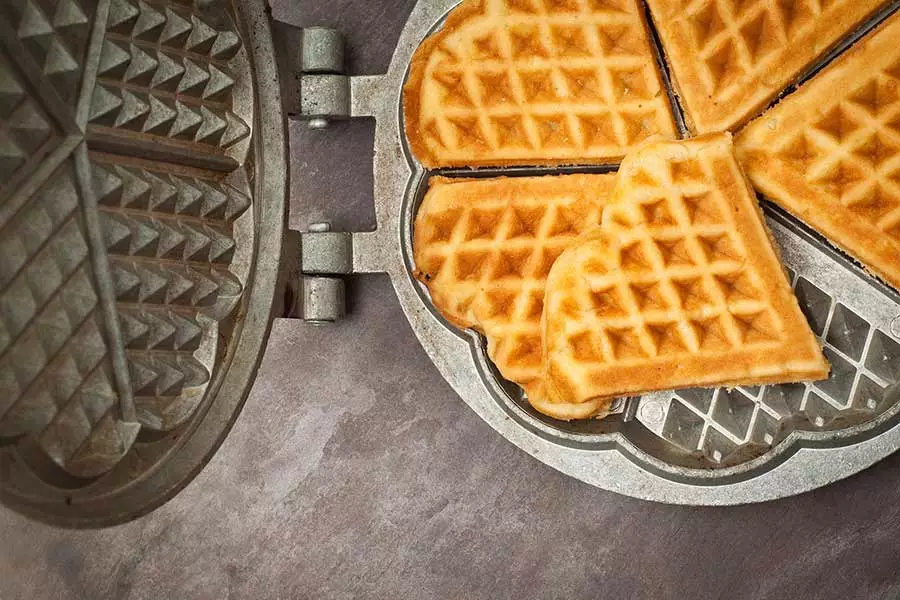 Home made heart shaped waffles served in a traditional cast iron waffle pan