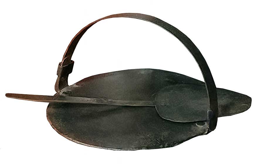 Image of a traditional Scottish cast iron girdle for making pancakes, scones and soda bread over a peat fire
